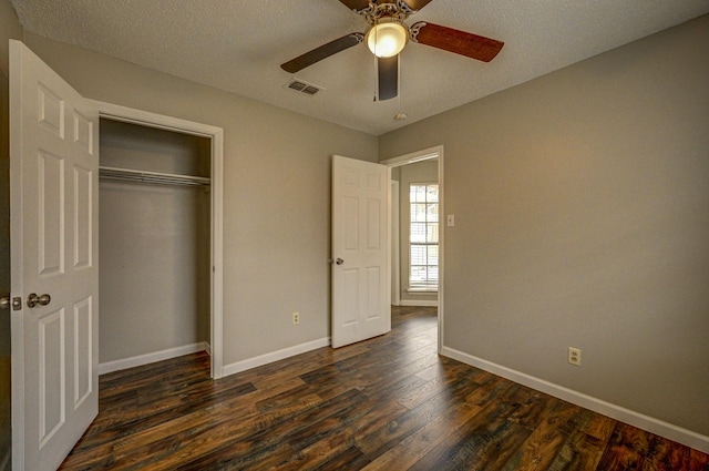 unfurnished bedroom featuring dark wood-type flooring, a ceiling fan, visible vents, baseboards, and a closet