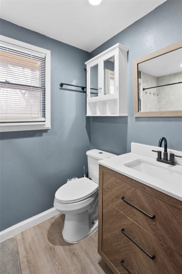 full bathroom with a shower with shower curtain, toilet, vanity, wood finished floors, and baseboards