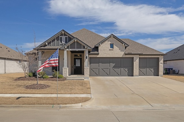 view of front of home with a shingled roof, concrete driveway, brick siding, and an attached garage