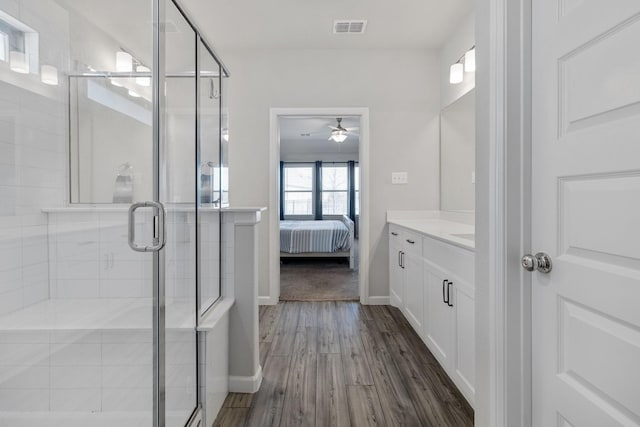 full bathroom featuring visible vents, a stall shower, connected bathroom, vanity, and wood finished floors