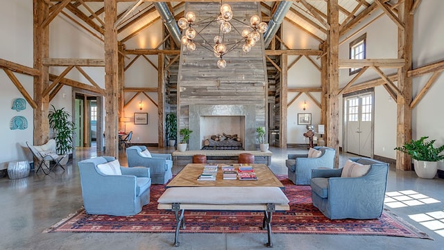 living room with baseboards, high vaulted ceiling, a fireplace, and a notable chandelier