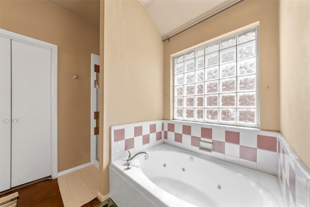 full bath with a jetted tub and vaulted ceiling