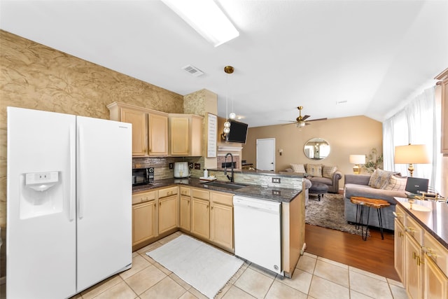 kitchen with white appliances, a sink, open floor plan, light brown cabinets, and lofted ceiling