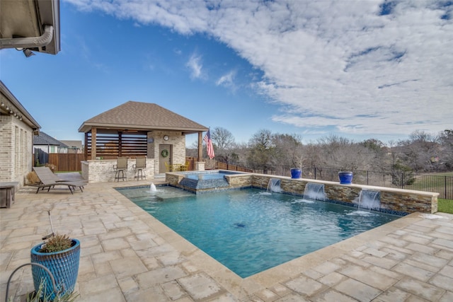 view of swimming pool featuring a fenced backyard, outdoor dry bar, a gazebo, a patio area, and a pool with connected hot tub