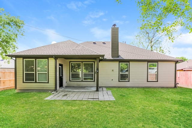 back of house featuring a patio, a chimney, fence, and a lawn