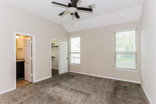 unfurnished bedroom with lofted ceiling, carpet floors, baseboards, and visible vents