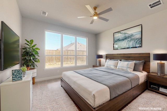 bedroom with baseboards, visible vents, ceiling fan, and light colored carpet