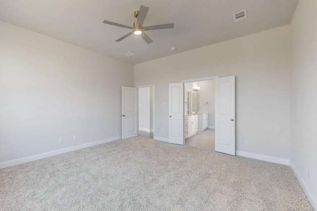 unfurnished bedroom featuring visible vents, a ceiling fan, light carpet, ensuite bath, and baseboards