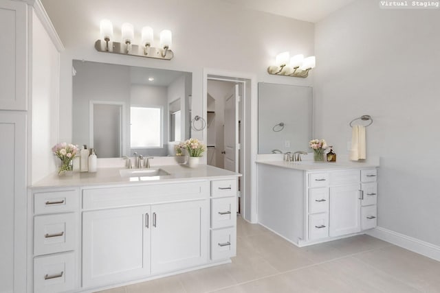 full bath with two vanities, a sink, baseboards, and tile patterned floors