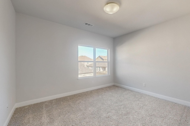 carpeted empty room featuring visible vents and baseboards