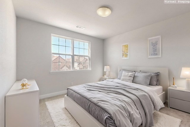 bedroom featuring light carpet, visible vents, and baseboards