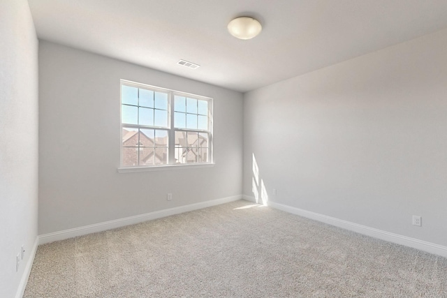 carpeted empty room featuring visible vents and baseboards