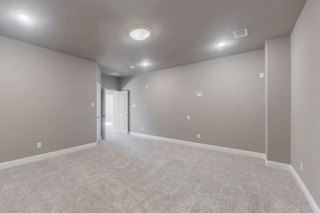 empty room featuring light carpet, recessed lighting, visible vents, and baseboards