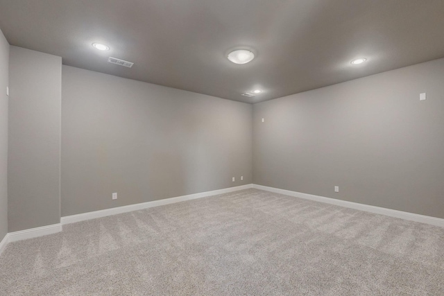 carpeted spare room featuring recessed lighting, visible vents, and baseboards