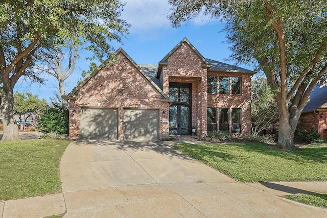 traditional-style home featuring brick siding, a garage, concrete driveway, and a front yard