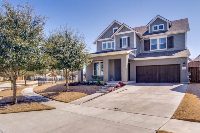 craftsman house with brick siding, concrete driveway, board and batten siding, fence, and a garage