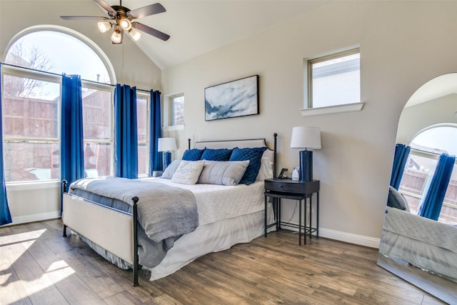 bedroom with ceiling fan, vaulted ceiling, baseboards, and wood finished floors