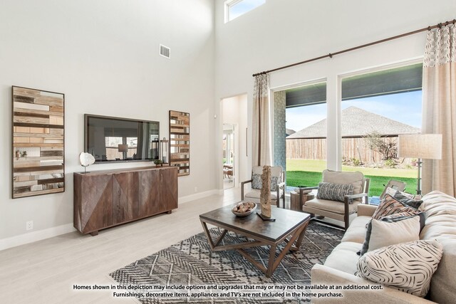 13133 Yellowstone Way, Providence Village, TX 76227 - living area featuring a high ceiling, wood finished floors, visible vents, and baseboards