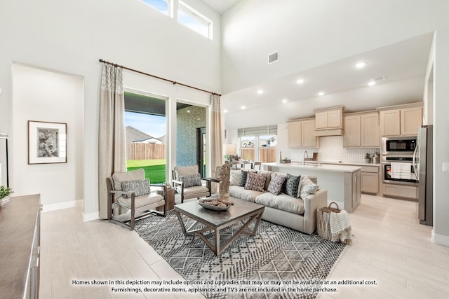 13133 Yellowstone Way, Providence Village, TX 76227 - living room with a towering ceiling, light wood finished floors, plenty of natural light, and visible vents