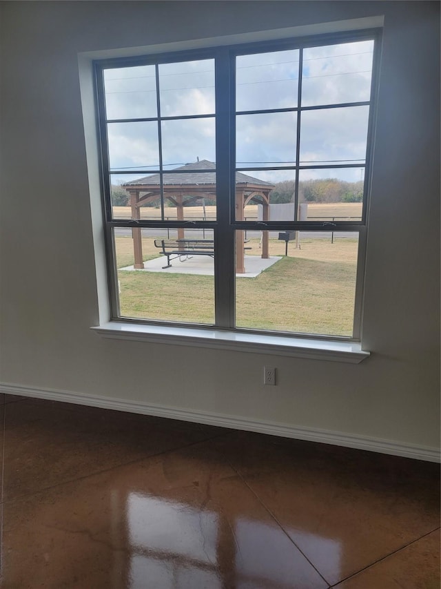 empty room featuring baseboards and a wealth of natural light