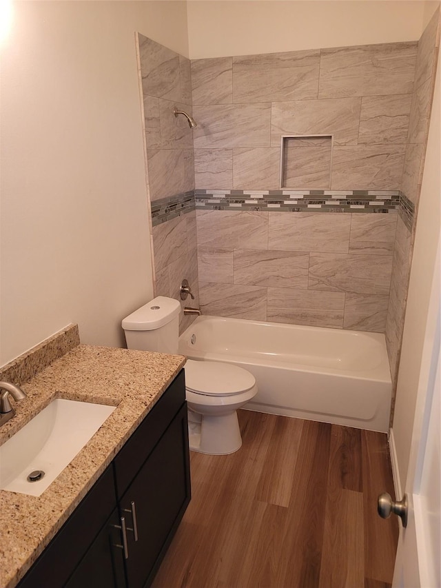 bathroom featuring  shower combination, vanity, toilet, and wood finished floors