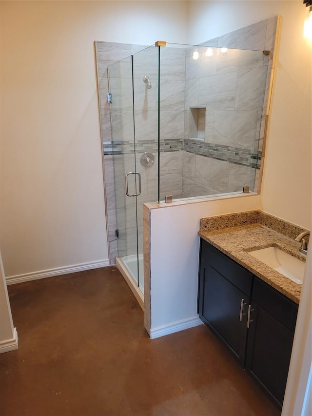 full bath with a stall shower, vanity, and baseboards