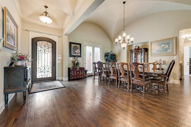 dining room featuring dark wood-type flooring, lofted ceiling, a notable chandelier, and baseboards