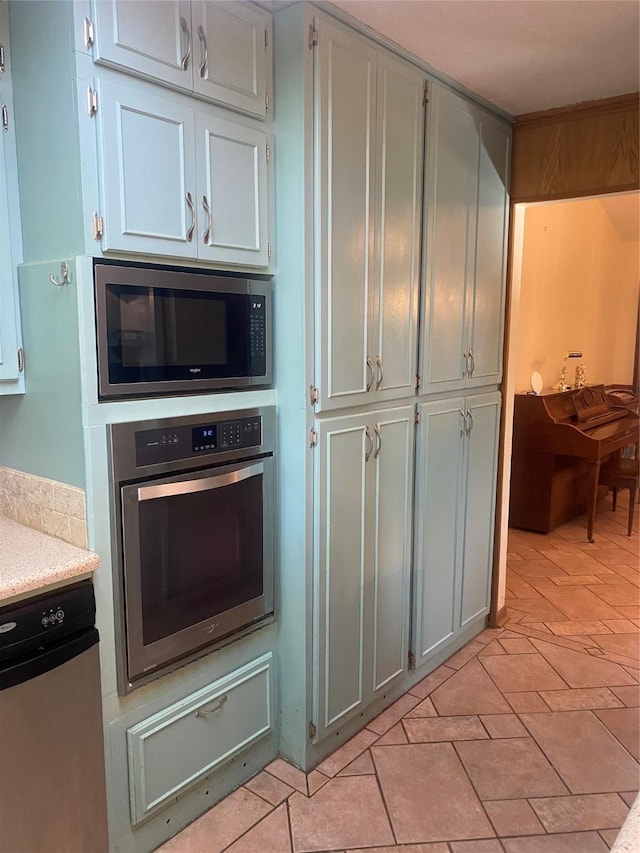 kitchen featuring light tile patterned floors, stainless steel appliances, and light countertops