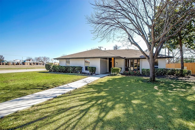 single story home with a front yard, fence, and brick siding