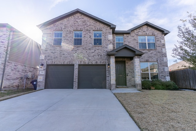 view of front of house with driveway, a garage, fence, and brick siding