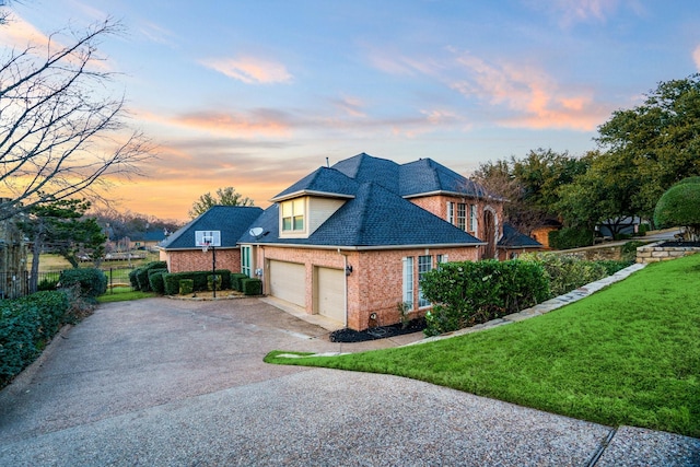 2781 Timber Crest Ln, Highland Village, TX 75077 - property exterior at dusk with brick siding, driveway, an attached garage, and roof with shingles