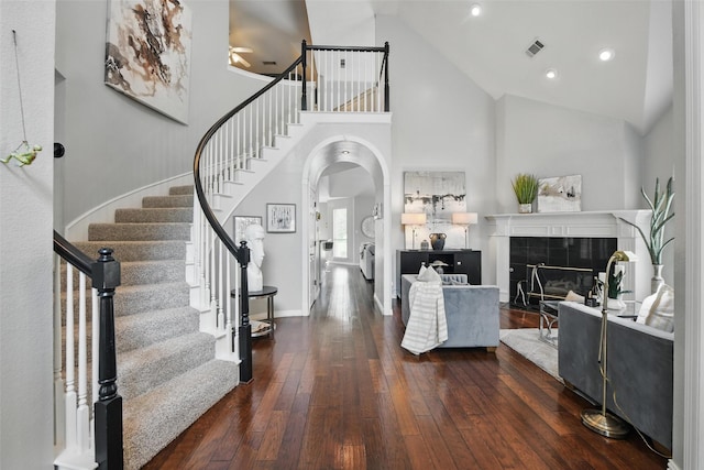 2781 Timber Crest Ln, Highland Village, TX 75077 - living room with high vaulted ceiling, dark wood finished floors, a ceiling fan, arched walkways, and stairs
