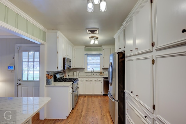 4606 Tibbs St, Shreveport, LA 71105 - kitchen featuring stainless steel appliances, white cabinetry, light wood-style floors, and a sink