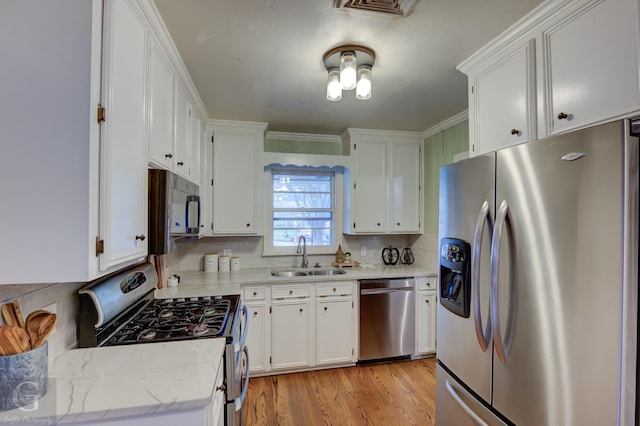 4606 Tibbs St, Shreveport, LA 71105 - kitchen featuring stainless steel appliances, a sink, white cabinetry, and light wood-type flooring