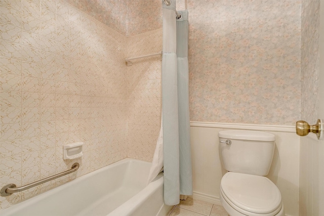 full bath featuring tile patterned flooring, toilet, a wainscoted wall, shower / bath combo with shower curtain, and wallpapered walls