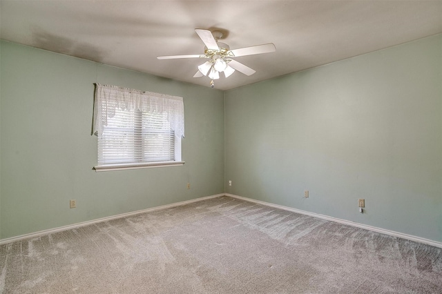 empty room featuring carpet floors, ceiling fan, and baseboards