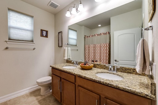 bathroom with toilet, double vanity, a sink, and visible vents