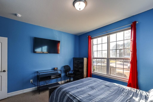 carpeted bedroom featuring multiple windows and baseboards