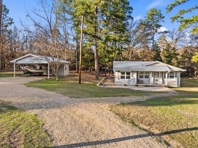 view of front of home featuring a carport, metal roof, a front lawn, and dirt driveway