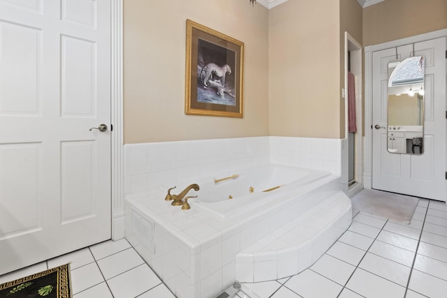 bathroom with a tub with jets, ornamental molding, and tile patterned floors