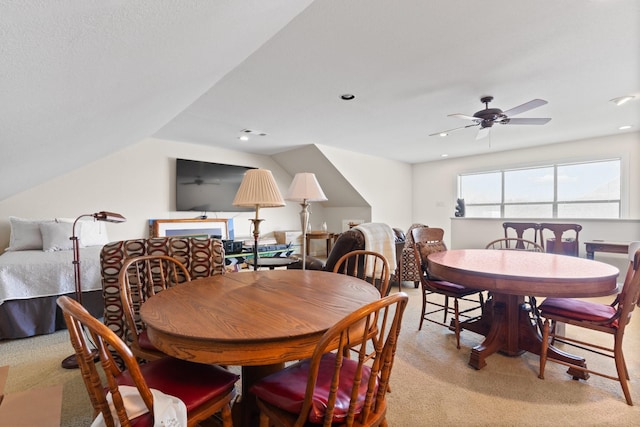 dining area featuring light colored carpet, vaulted ceiling, and ceiling fan