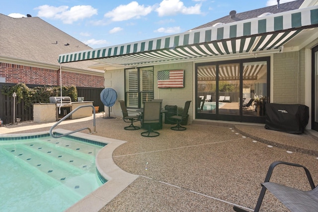 view of swimming pool with grilling area, a patio area, fence, and a fenced in pool