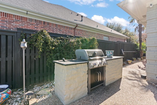 view of patio / terrace with exterior kitchen, area for grilling, and fence