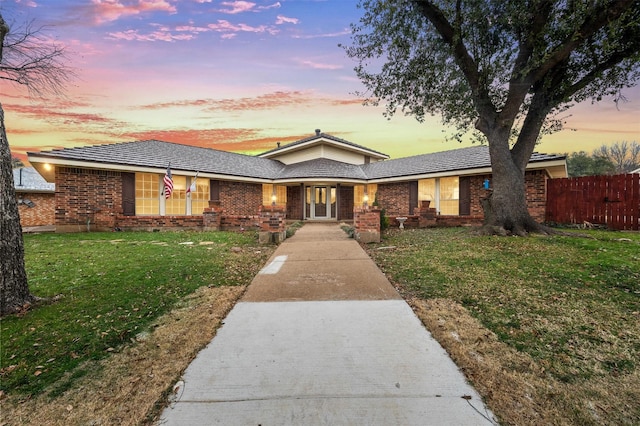 single story home featuring brick siding, a front lawn, and fence