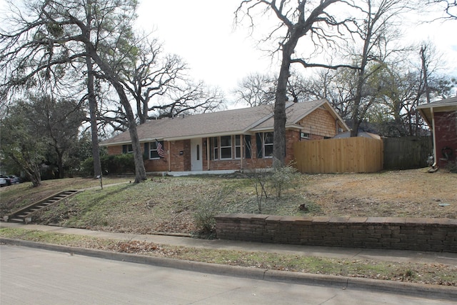 view of front of home with brick siding and fence