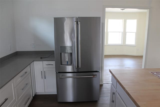 kitchen with high end fridge, butcher block counters, dark wood finished floors, and white cabinetry