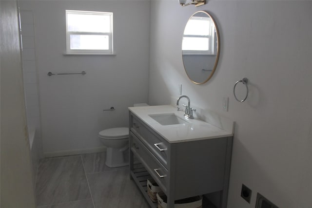 full bath featuring baseboards, vanity, and toilet