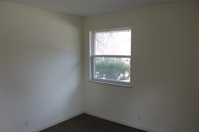 unfurnished room featuring dark wood-style flooring and baseboards