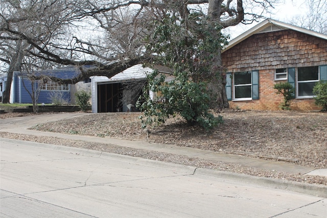 view of front of house featuring a garage, concrete driveway, and brick siding