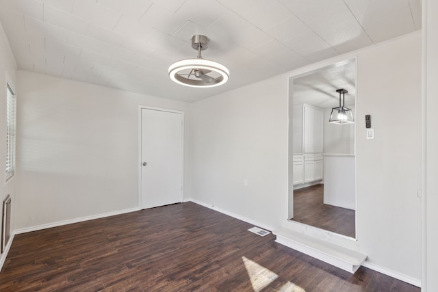 interior space featuring dark wood-style flooring, visible vents, and baseboards